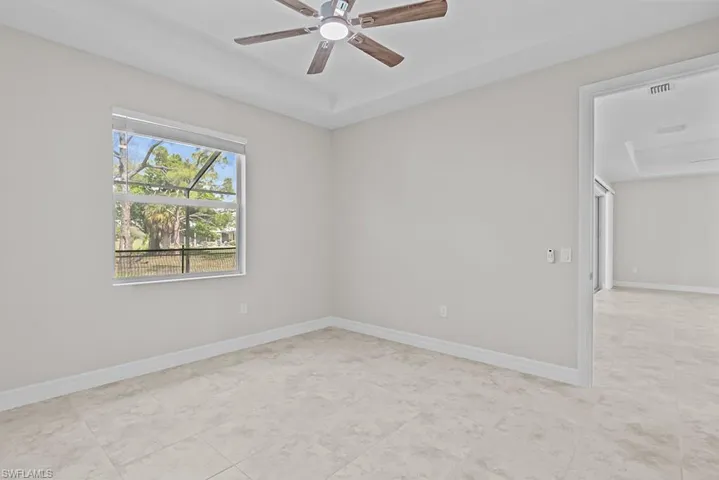 Spare room featuring a ceiling fan and baseboards