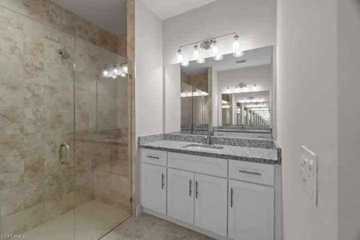 Bathroom featuring a stall shower and vanity