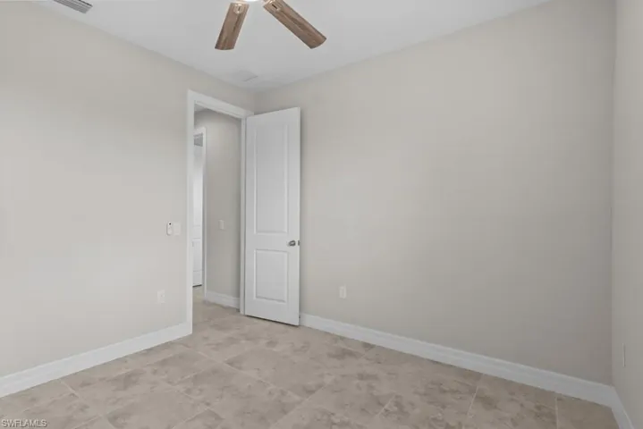 Unfurnished room with baseboards and a ceiling fan