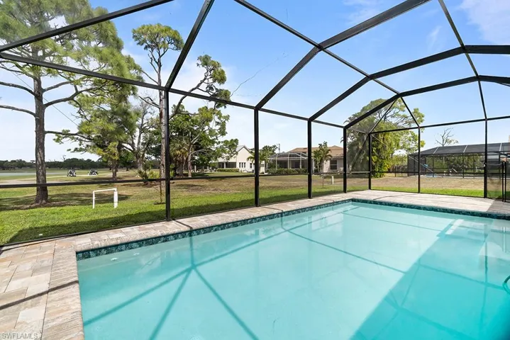 Outdoor pool featuring a yard, a sunroom, and a lanai