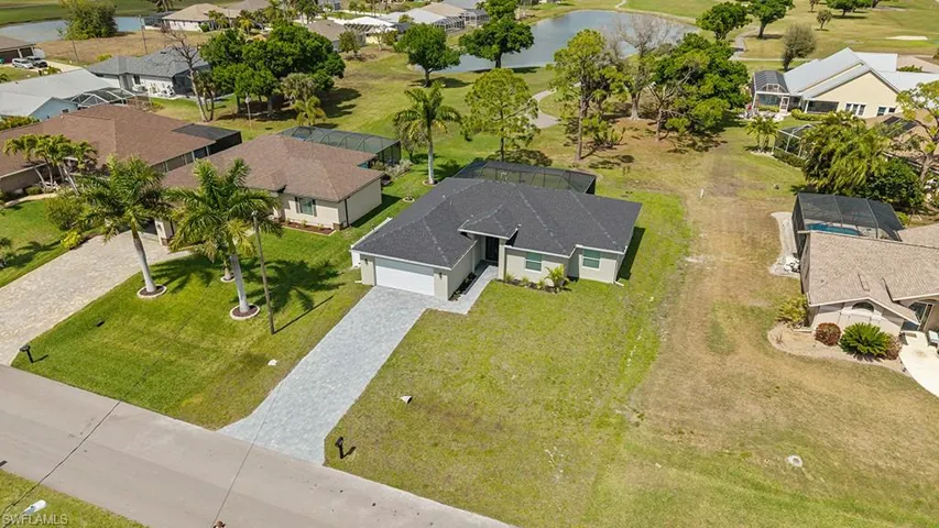 Aerial perspective of suburban area with a nearby body of water and a golf club