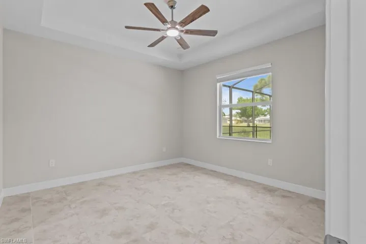 Master bedroom featuring ceiling fan and a raised ceiling