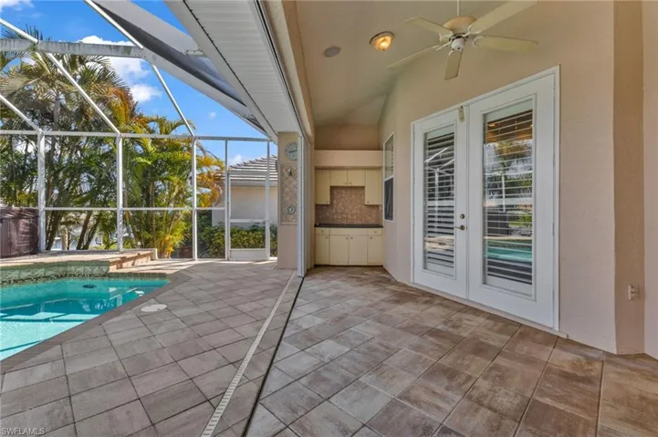 Outdoor pool with a patio area, french doors, a sunroom, and glass enclosure