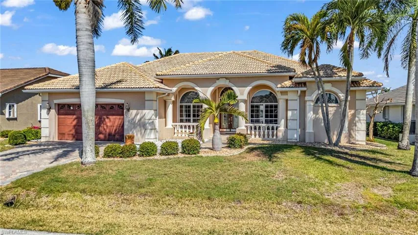 Mediterranean / spanish-style home with stucco siding, decorative driveway, a front lawn, an attached garage, and a tiled roof