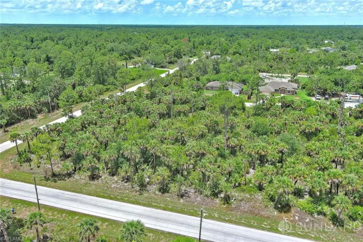 Aerial view of property's location with a forest
