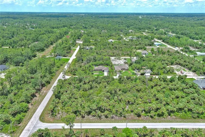 Aerial overview of property's location with a heavily wooded area