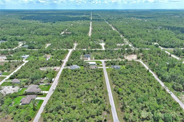Aerial view of property's location with a heavily wooded area