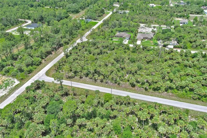 Aerial view of property and surrounding area featuring a heavily wooded area