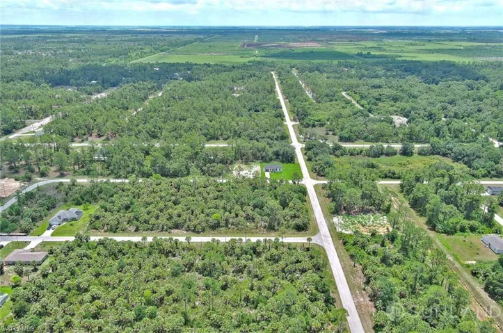 View of property location with a heavily wooded area