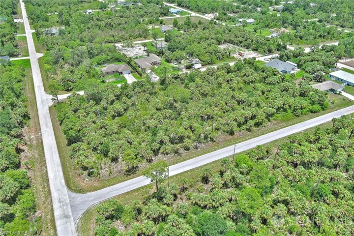 View of property location featuring a tree filled landscape