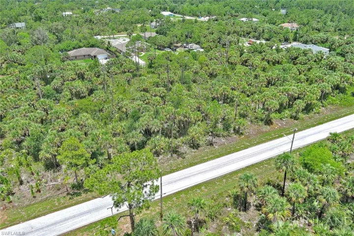 Aerial view of property's location with a heavily wooded area