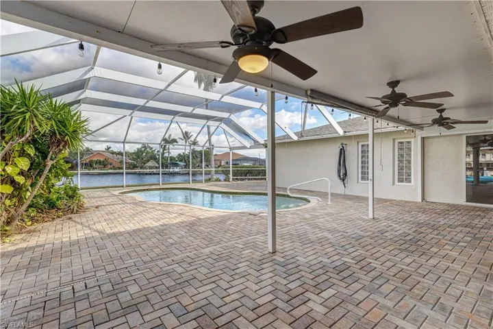 Outdoor pool with a lanai, a patio area, and a ceiling fan