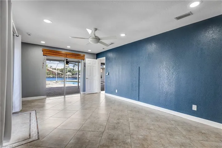 Unfurnished room featuring visible vents, a textured wall, baseboards, and ceiling fan