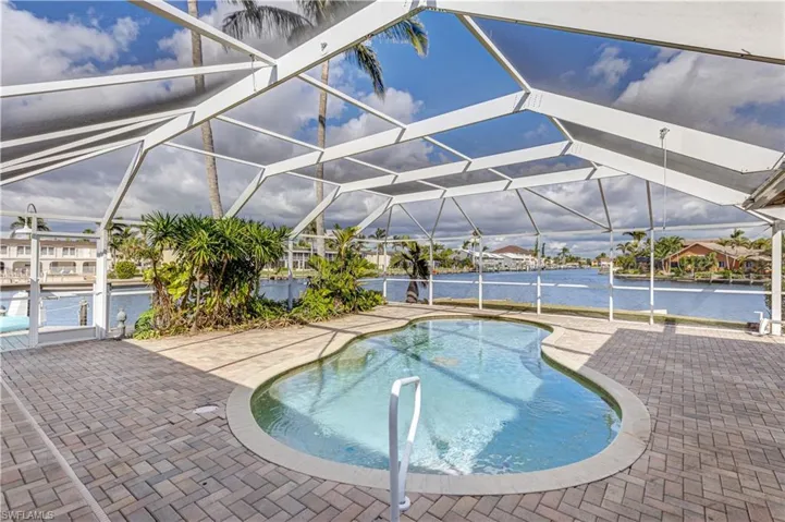 Pool featuring a patio area, a lanai, and a water view