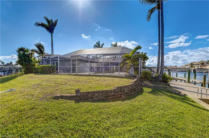 View of yard featuring glass enclosure, a dock, and a water view