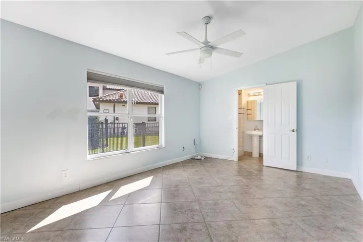 Unfurnished room featuring vaulted ceiling, ceiling fan, tile patterned flooring, and baseboards