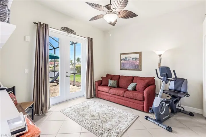 4th Bedroom/Den with french doors, ceiling fan, and light tile floors facing pool area