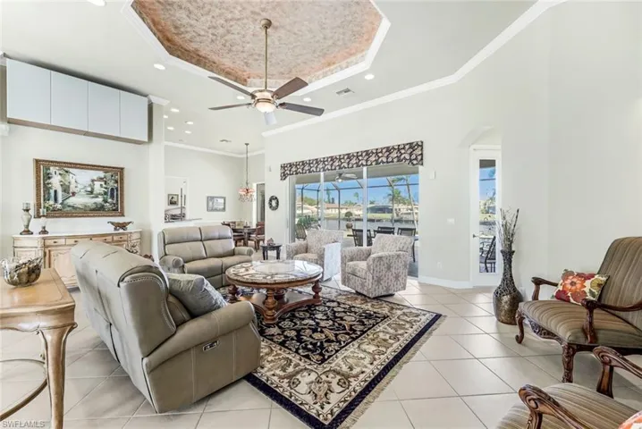 Great Room with ornamental molding, ceiling fan, and a raised ceiling
