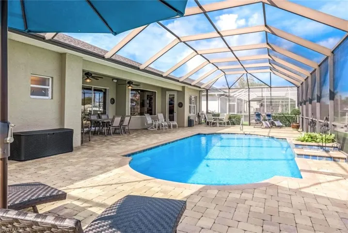 View of pool featuring a oversize pool deck, lanai