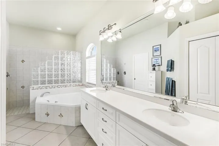 Primary Bathroom with vanity, independent shower and bath, and tile floors