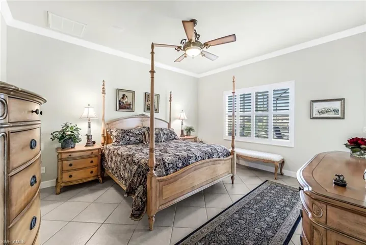 Tiled Primary bedroom with crown molding and ceiling fan