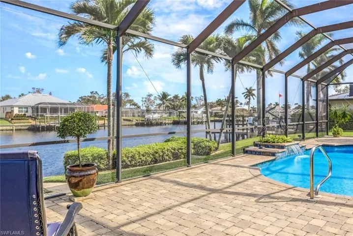 View of pool featuring oversize pool deck, pool water feature, a water view
