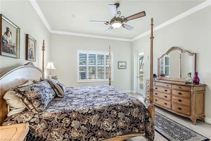 Primary bedroom featuring access to outside, crown molding, and ceiling fan