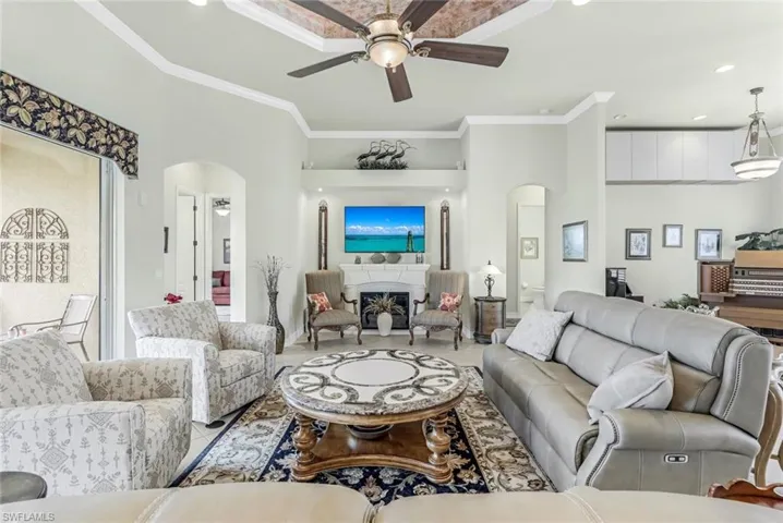 Great Room featuring crown molding, tray ceiling and ceiling fan