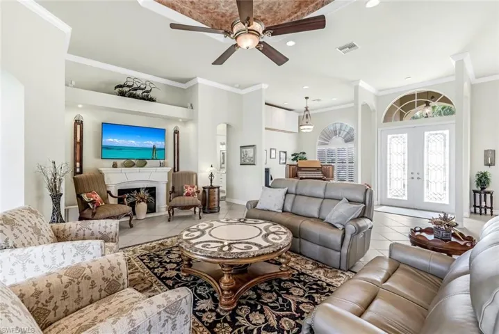 Great Room featuring crown molding, light tile patterned floors, and ceiling fan