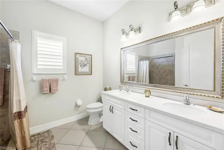 Bathroom featuring vanity, a shower with shower curtain, and tile flooring