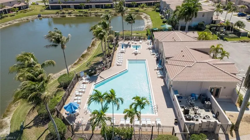 Aerial view of residential area with a large body of water and a pool