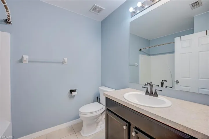 Full bath with vanity and light tile patterned floors
