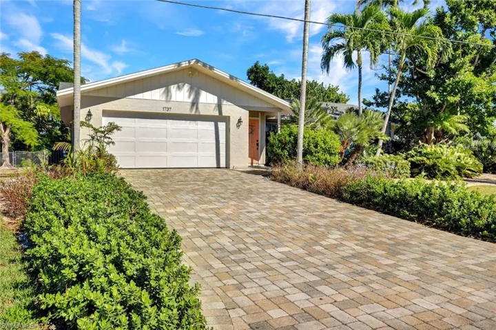 View of front of house with decorative driveway and an attached garage