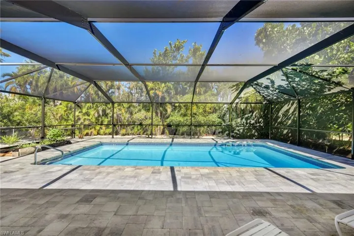 Swimming pool featuring a lanai, a sunroom, and a patio area
