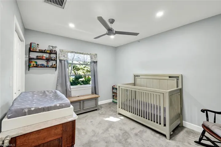 Bedroom featuring carpet floors, ceiling fan, a nursery area, and recessed lighting