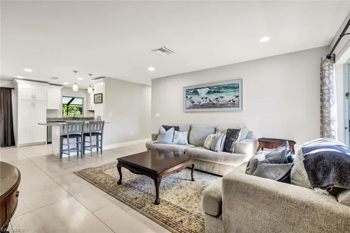 Living area featuring recessed lighting, a barn door, and light tile patterned flooring