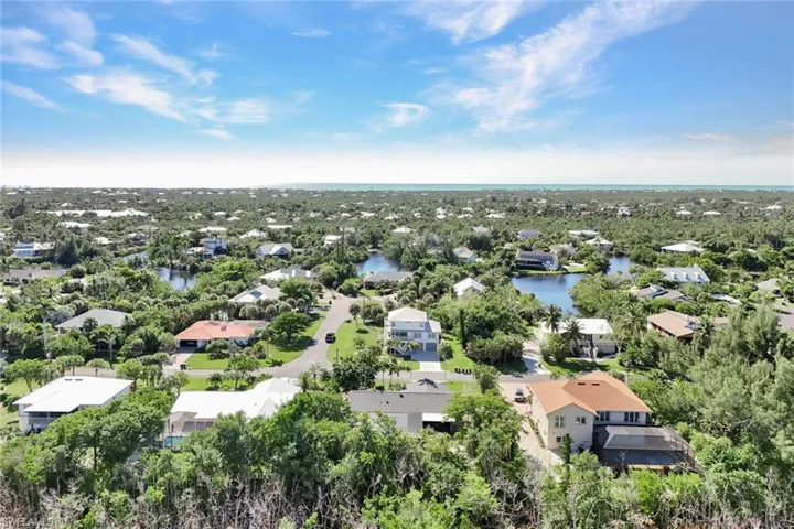 Aerial perspective of suburban area featuring a nearby body of water
