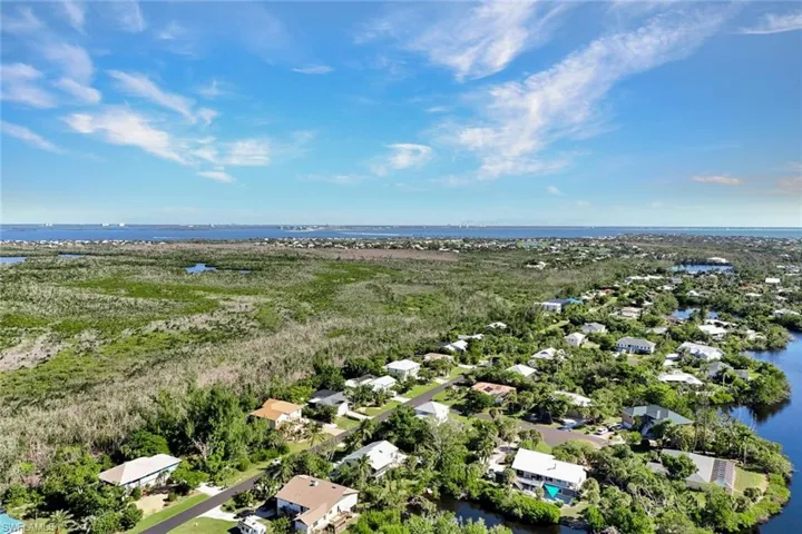 Aerial overview of property's location featuring a large body of water and nearby suburban area