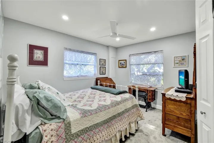 Bedroom with carpet flooring, multiple windows, ceiling fan, and recessed lighting
