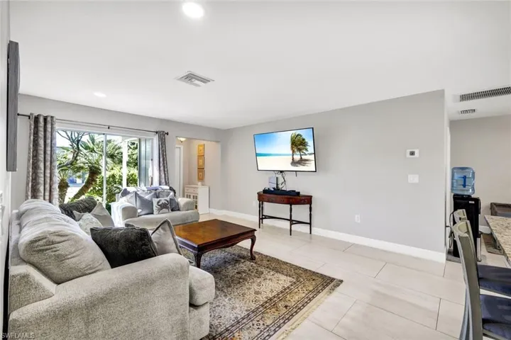 Living room with recessed lighting and light tile patterned flooring
