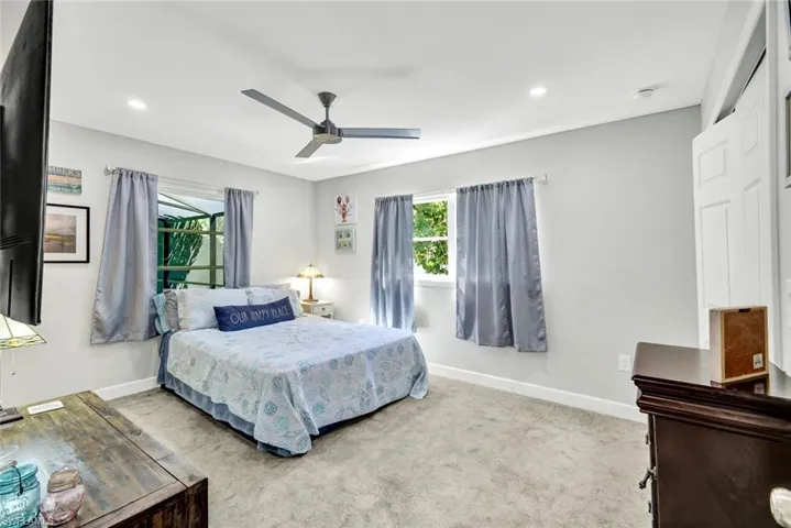 Bedroom featuring light carpet, ceiling fan, and recessed lighting