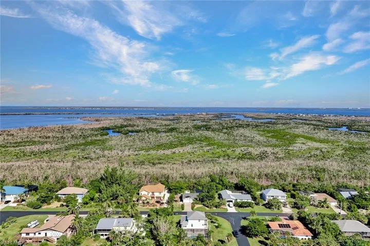 Aerial perspective of suburban area featuring a nearby body of water