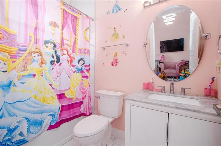 Full bathroom featuring shower / tub combo, vanity, and toilet