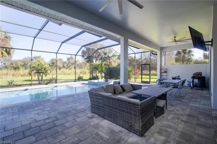 View of patio featuring an outdoor living space, area for grilling, a lanai, and ceiling fan