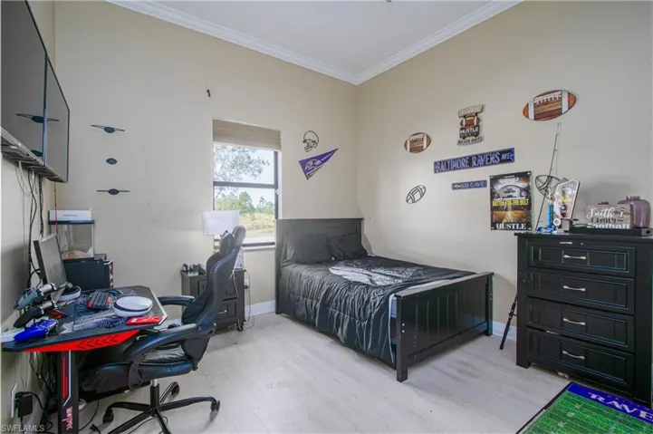 Bedroom featuring crown molding and light hardwood / wood-style flooring
