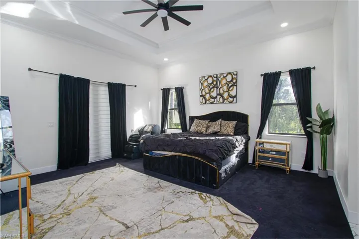 Bedroom featuring a tray ceiling, ceiling fan, and crown molding