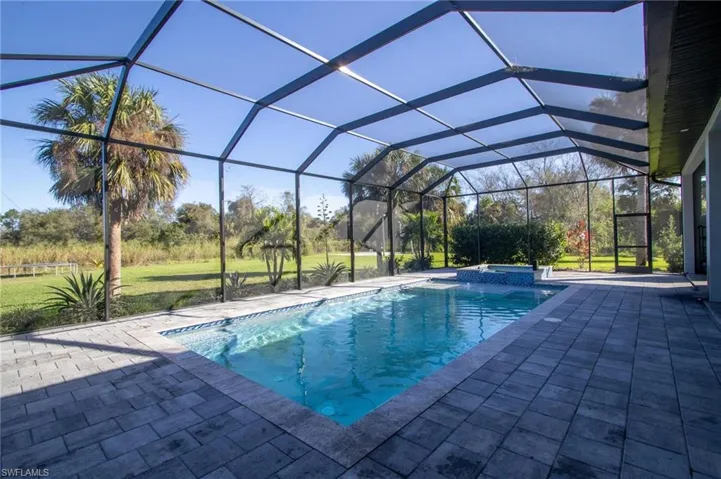 View of pool with a lanai, an in ground hot tub, and a patio