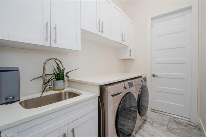 Washroom featuring cabinets, washer and clothes dryer, and sink