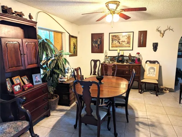 Dining area featuring light tile patterned floors, a textured ceiling, and ceiling fan