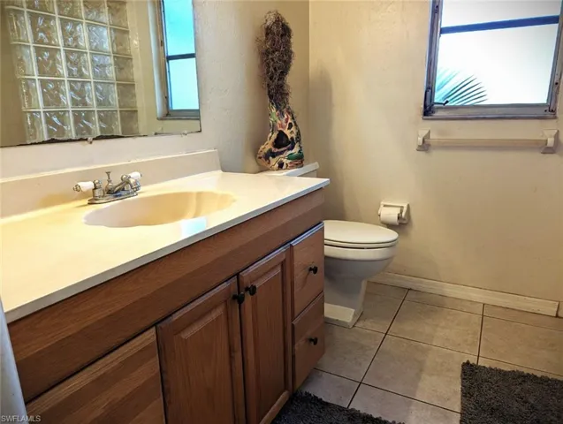 Bathroom with vanity, tile patterned floors, and toilet